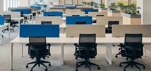 Modern open-plan office space featuring clean workstations, ergonomic chairs, and sanitized carpets provided by professional office cleaning services in Tulsa, OK.